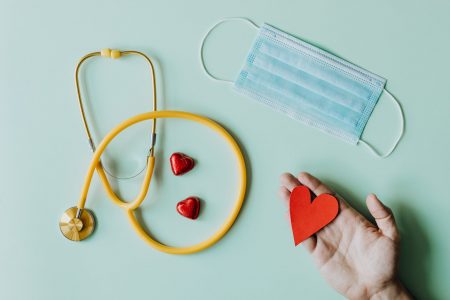 medical stethoscope and mask composed with red foiled chocolate hearts