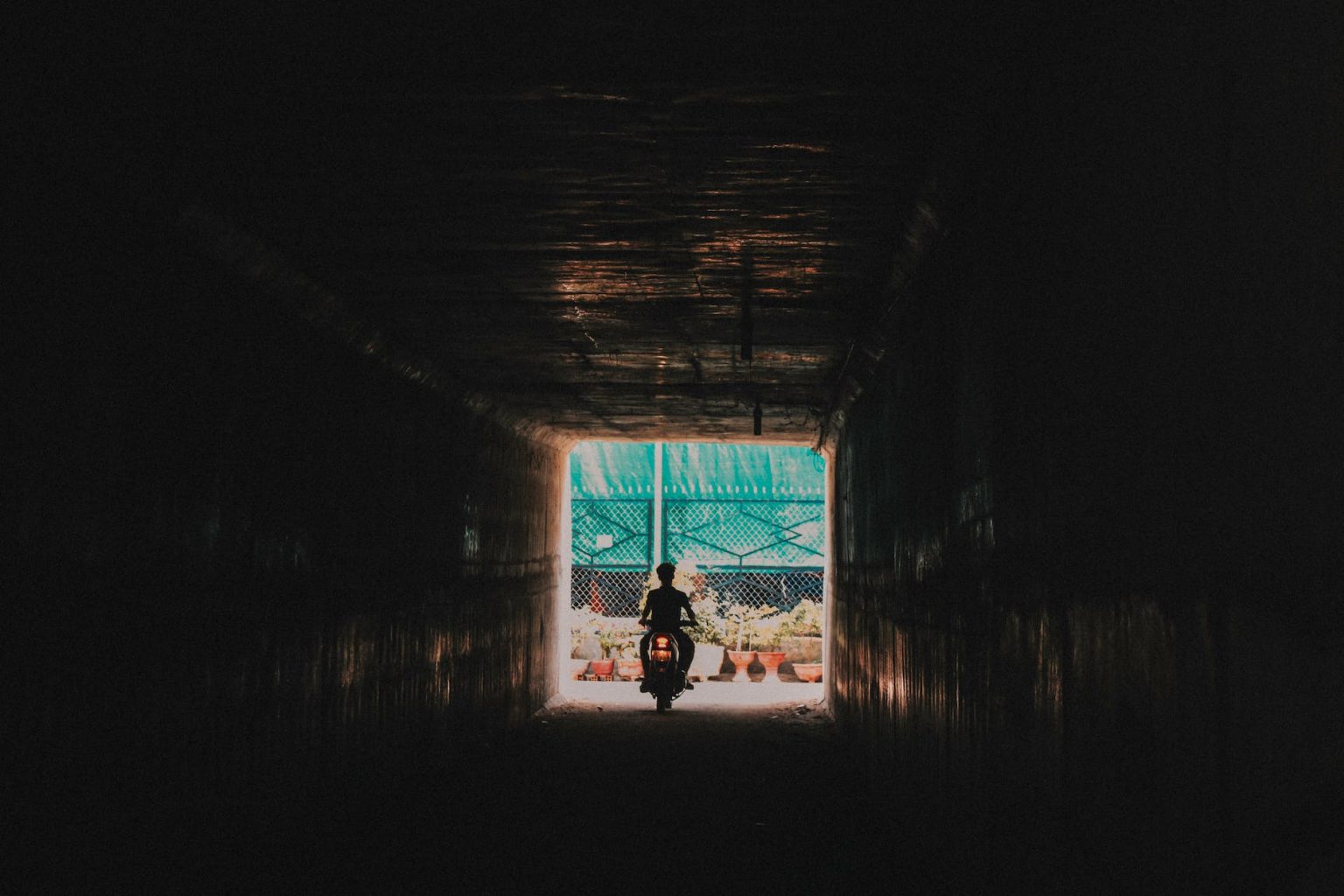 person riding a motorcycle going out from the tunnel