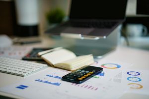 calculator on smartphone touchscreen on desk with graphs