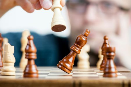 man holding chess piece